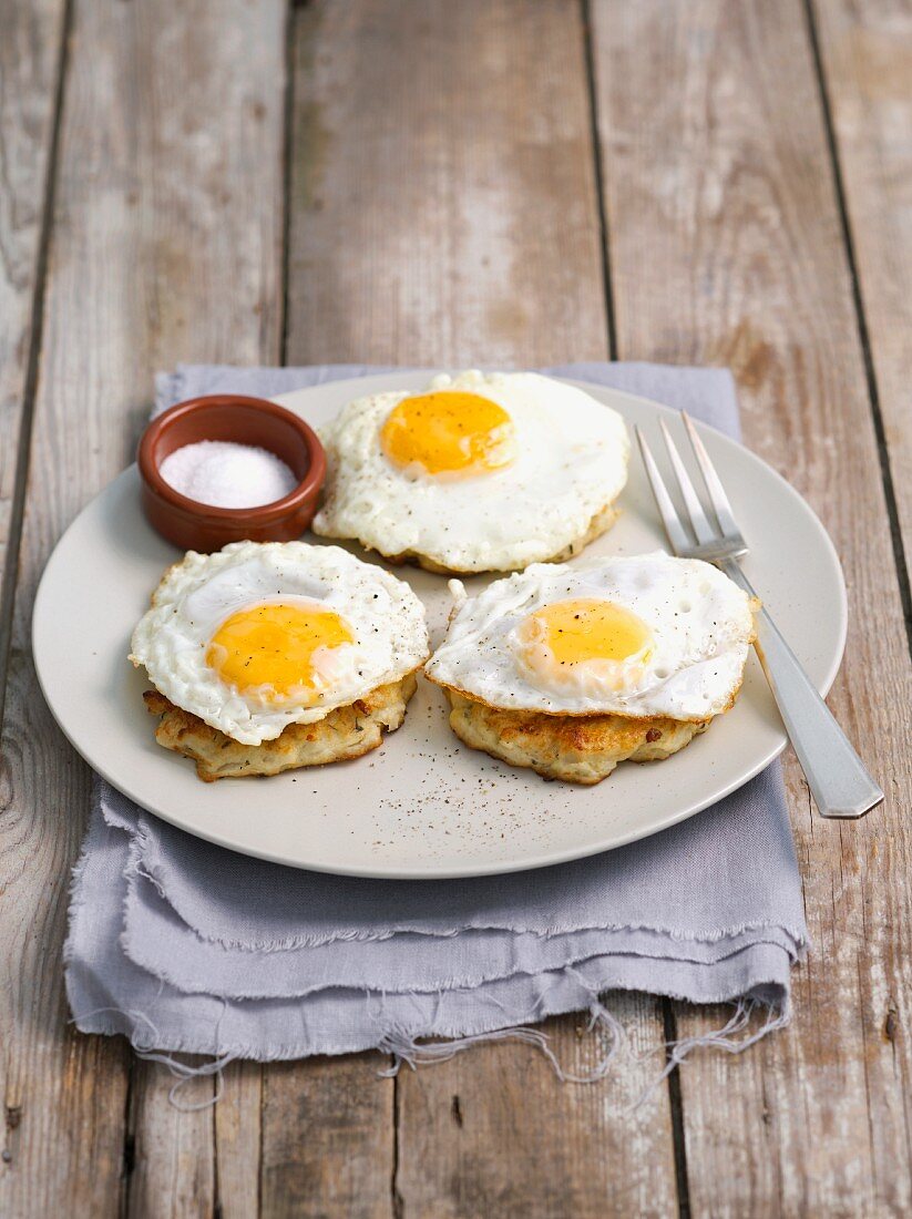 White cabbage and potato fritters topped with fried eggs