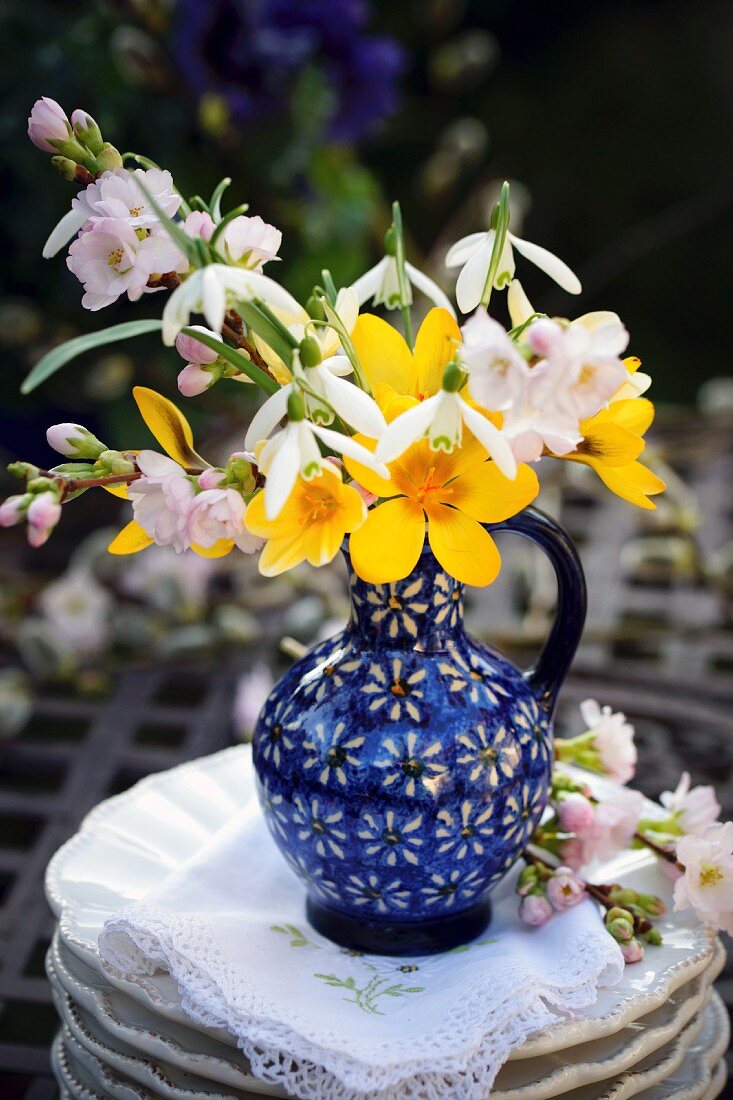 Spring posy of cherry blossom, crocuses & snowdrops in blue vase