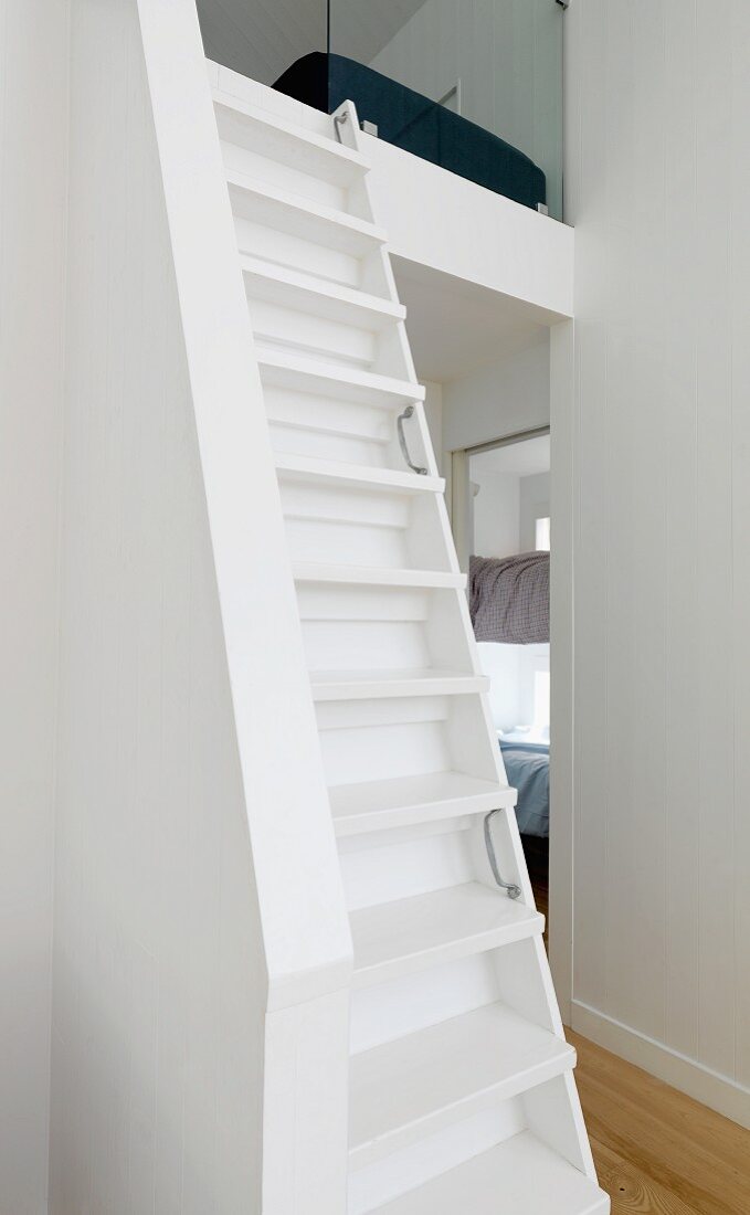 Narrow white staircase leading to mezzanine