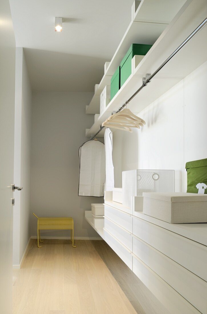 Dressing room with open wardrobe and white drawer module