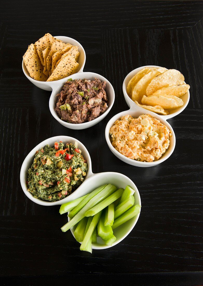 Various dips with crisps and celery sticks