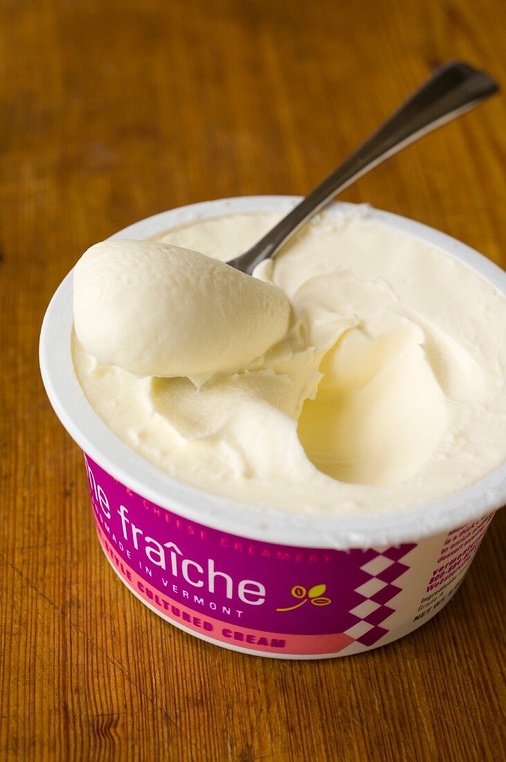 A pot of crème fraîche with a spoon