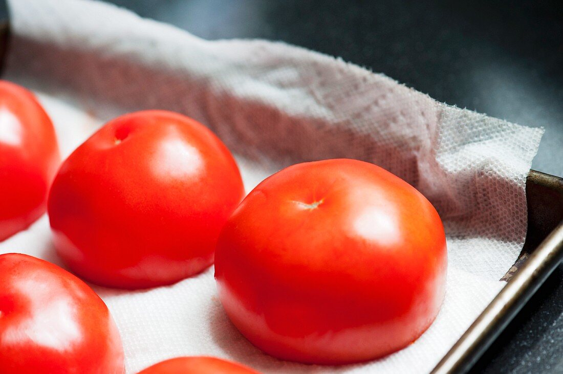 Hollowed out tomatoes on a baking tray