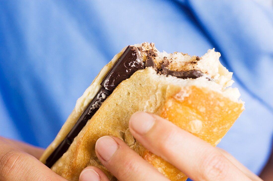 Hand hält Sandwich mit Schokolade