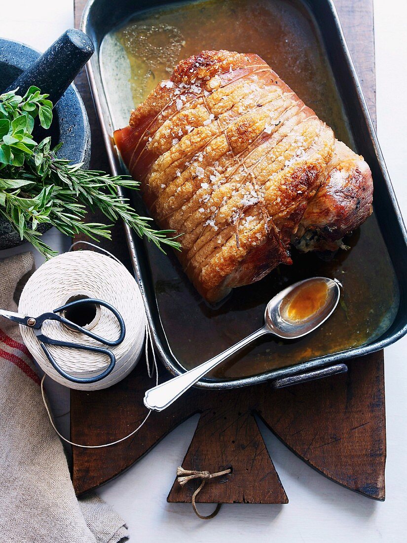Porchetta (Italian-style roast pork) in a roasting tin
