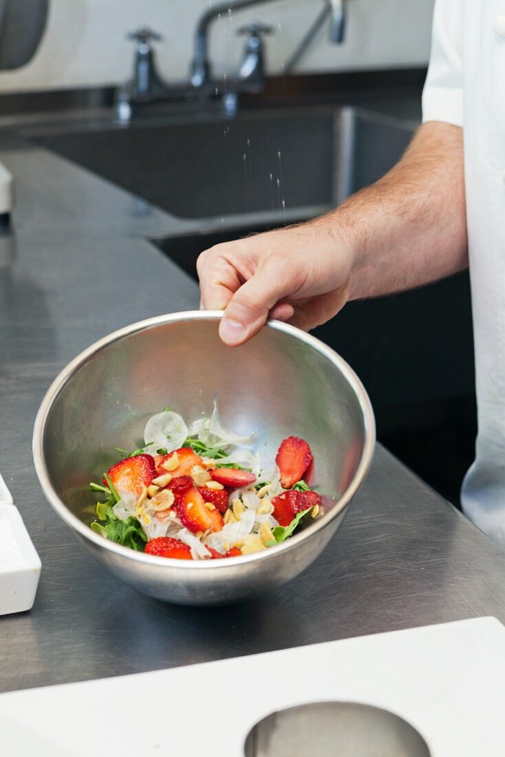 Chef Preparing Strawberry & Arugula Salad, marcona almonds, aged sherry vinaigrette, chevre, onion marmalade