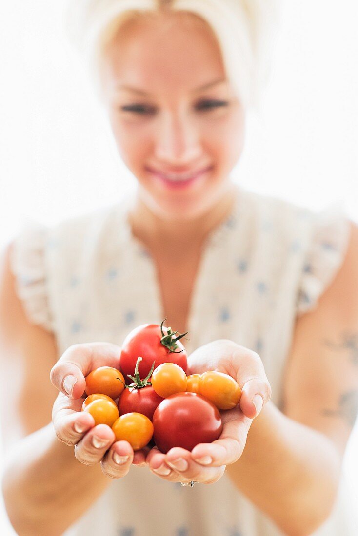 Frau hält Tomaten in den Händen
