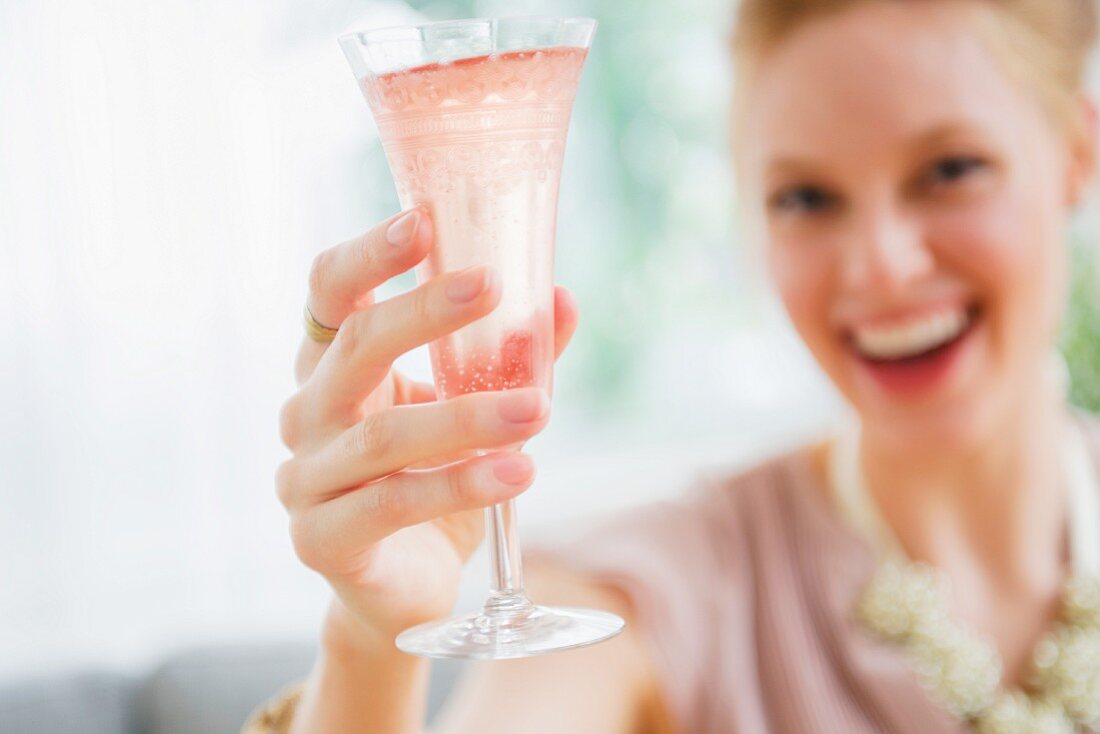 A young woman toasting with a glass of champagne