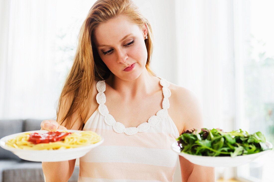 Frau wählt zwischen Pasta und Salat