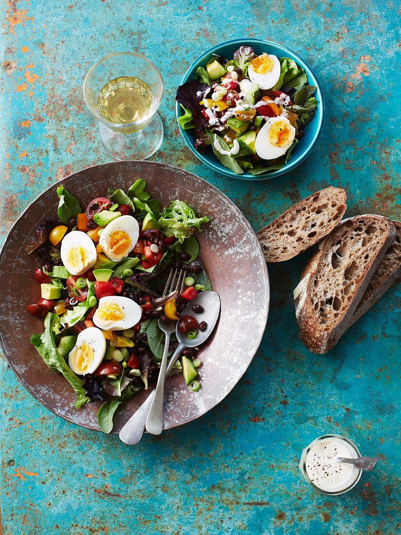 A mixed salad with boiled eggs, beans and rye bread