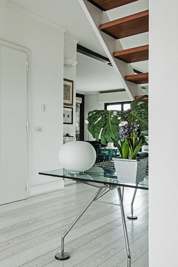 Spherical table lamp on Nomos designer table (by Norman Foster) in open-plan interior