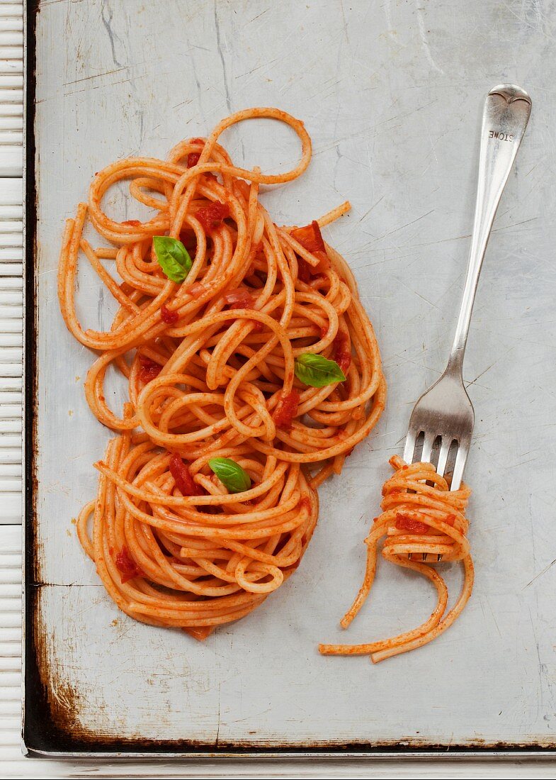 Spaghetti with tomato sauce on a baking tray