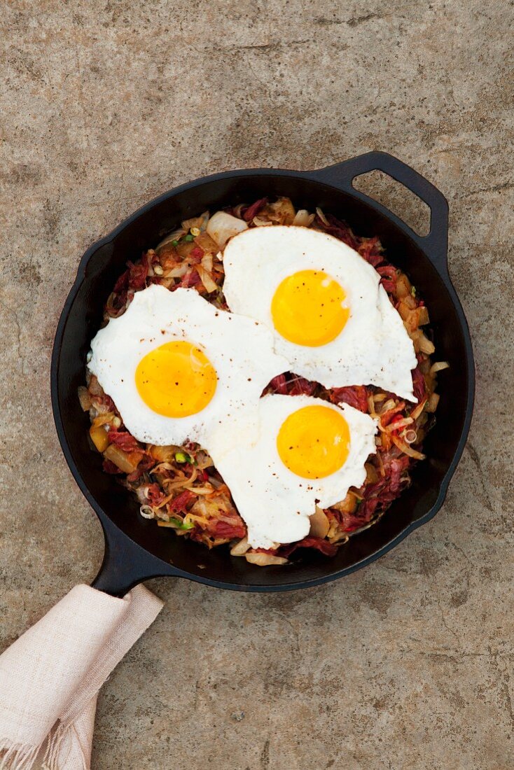 Hash browns with corned beef and fried eggs