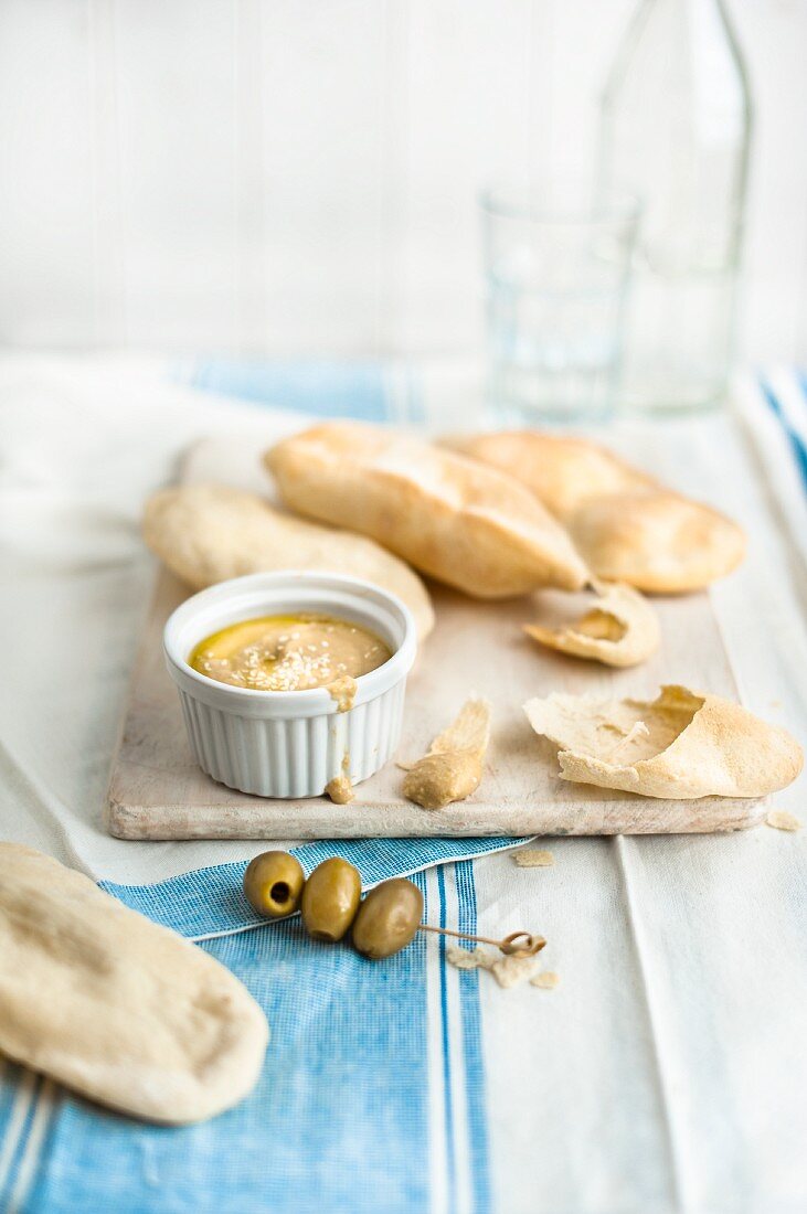 Hummus with unleavened bread and olive skewers