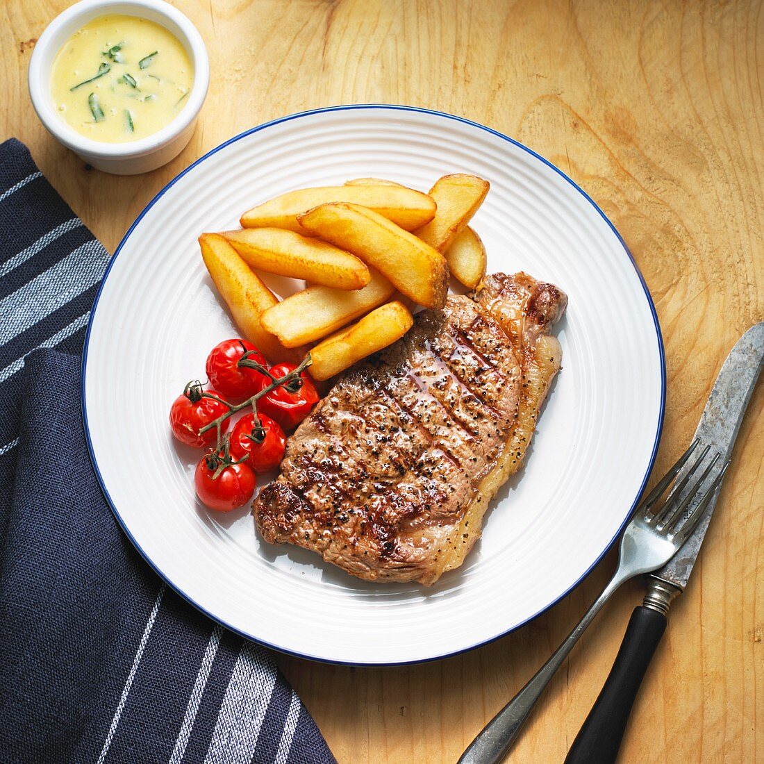 Beef steak with Bearnaise sauce, chips and cherry tomatoes