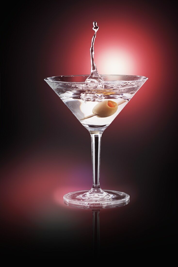 An olive splashing into a Martini