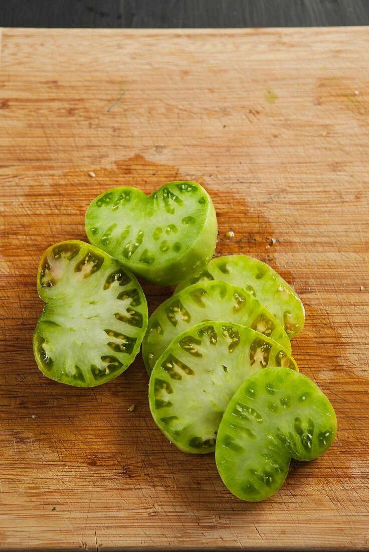 Sliced tomatillos on a wooden board