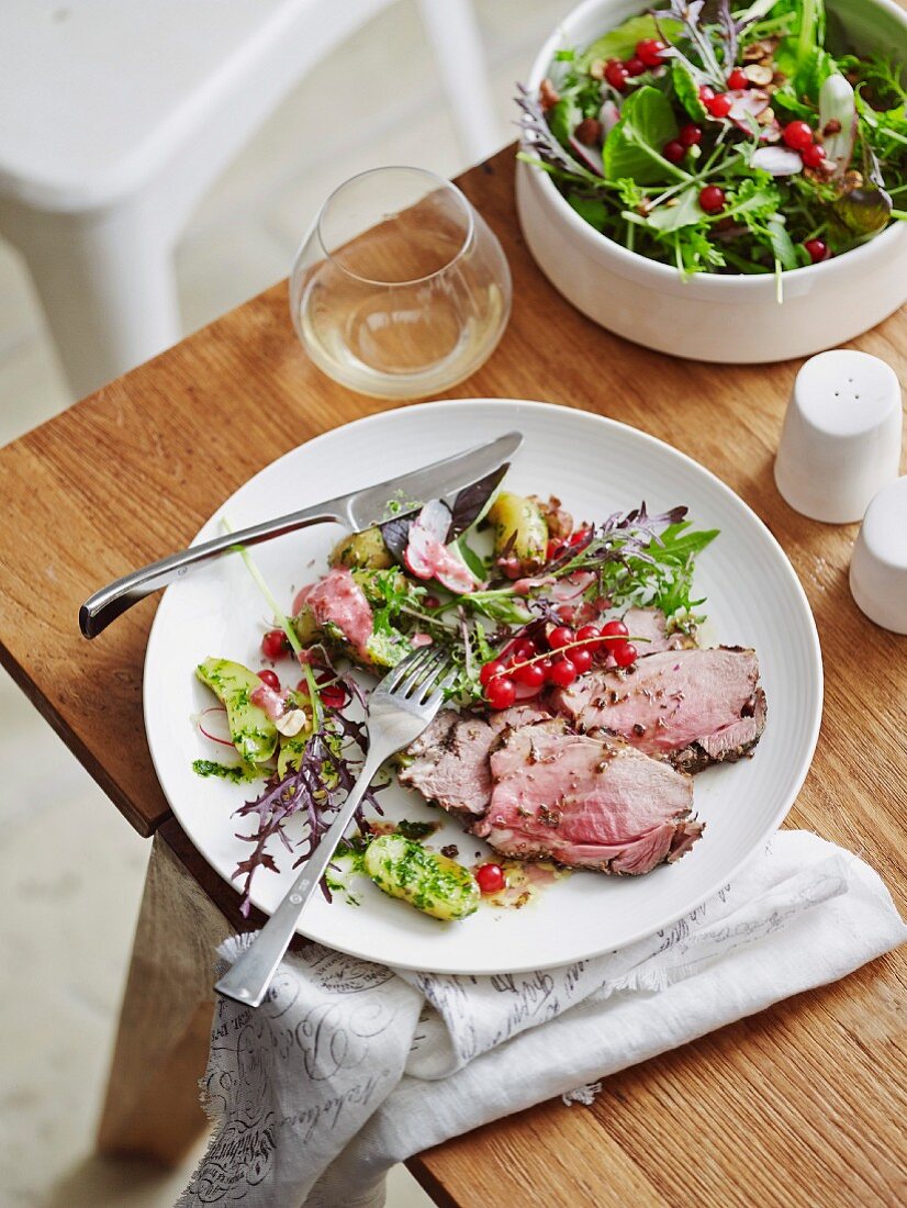 Glazed roast lamb with herb flowers and redcurrants