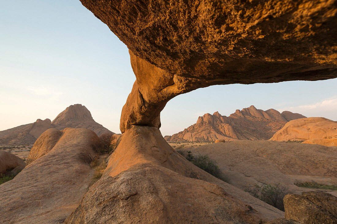 Felsbrücke 'Rock Arch' im Spitzkoppe-Gebiet mit Blick auf die Pondok-Berge, Erongo-Gebirge, Namibia
