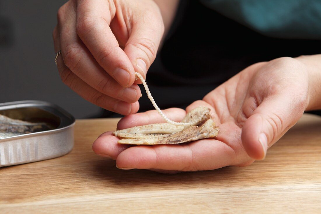 Tinned sardines being deboned