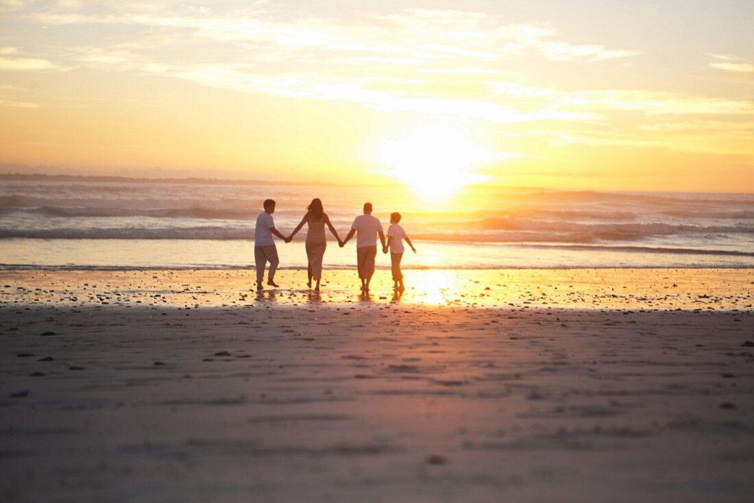 Family holding hands on beach, Cape Town, South Africa