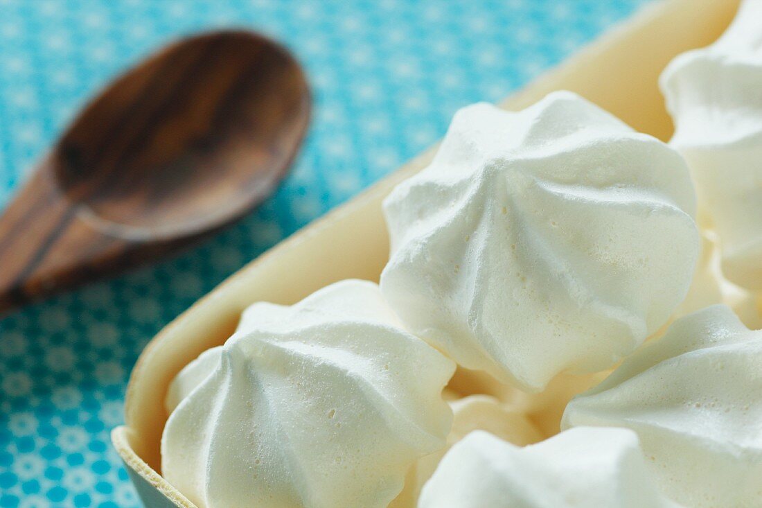 White meringues in a wooden dish