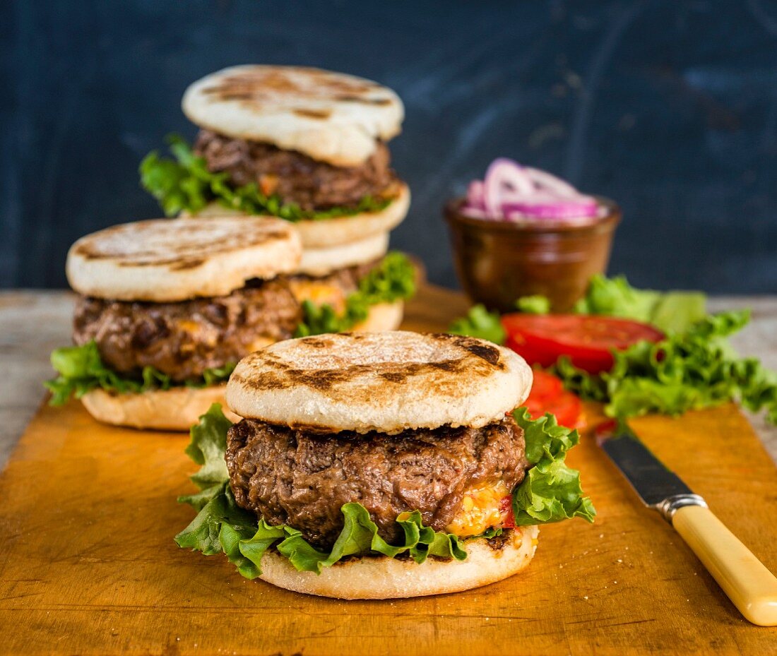 Hamburger mit Käsefüllung, Tomaten, Zwiebeln und Salat