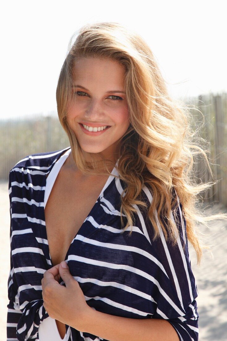 A young blonde woman wearing a blue-and-white striped jacket