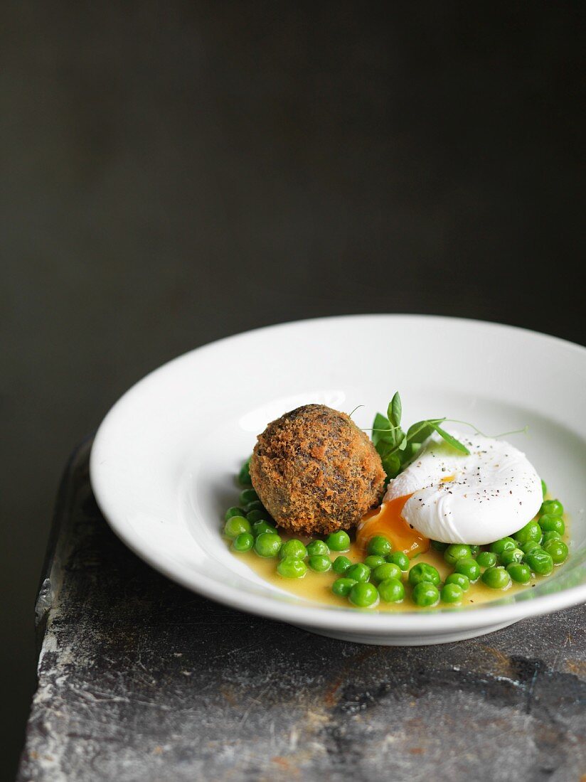 Breaded black pudding with a poached egg and peas