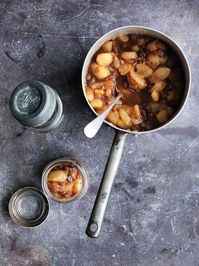 Pear chutney in a saucepan and a preserving jar