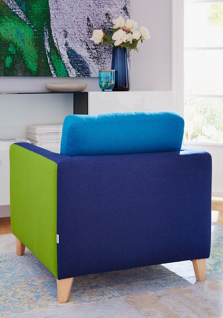 A comfortable patchwork armchair in blue and green on a rug