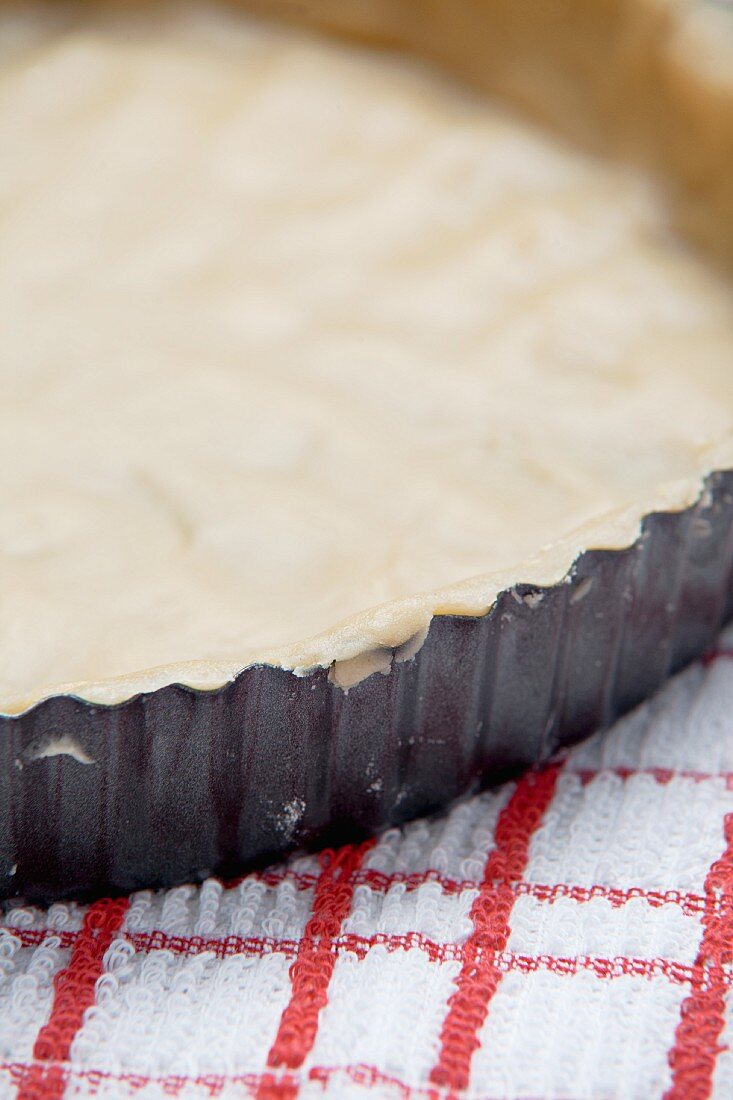 Unbaked shortcrust pastry in a baking tin