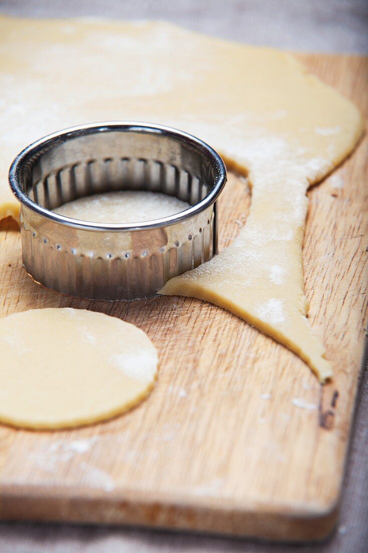 Round shortcrust biscuits being cut out
