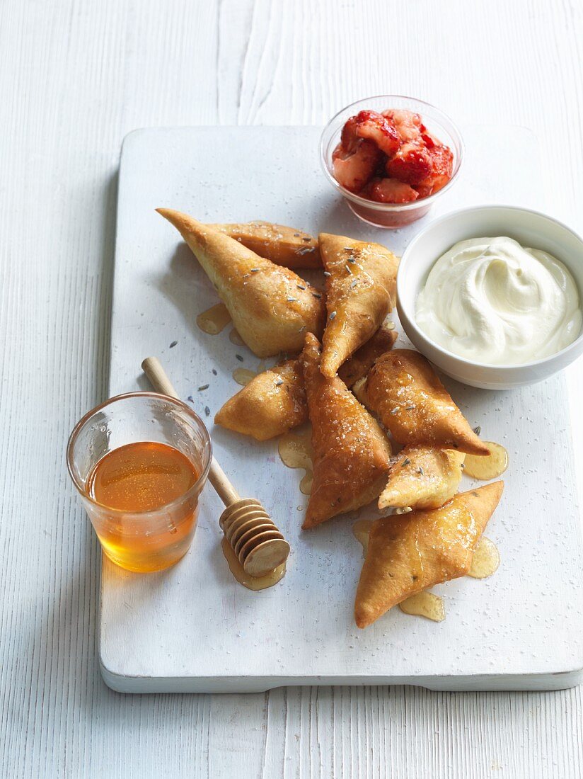 Deep-fried pastry parcels with lavender honey, strawberries and yogurt cream