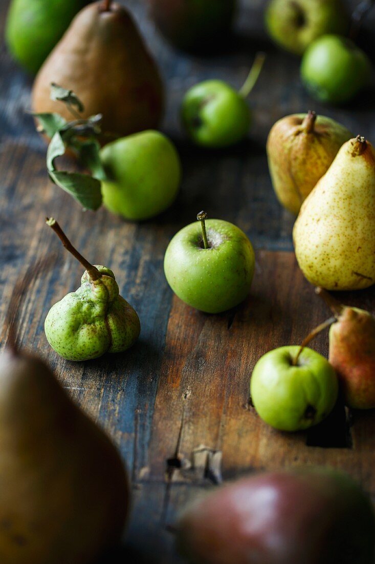 Verschiedene Bio-Äpfel und Birnen auf Holzuntergrund