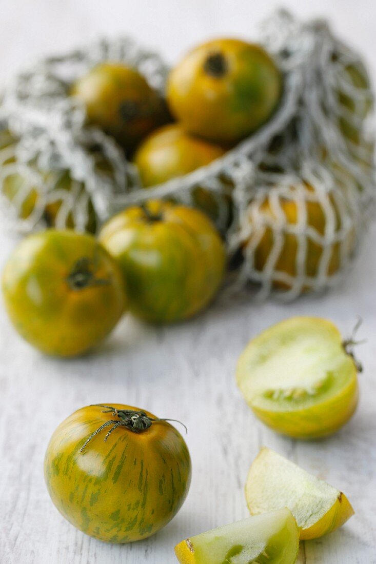 Grüne Tomaten, teilweise im Einkaufsnetz
