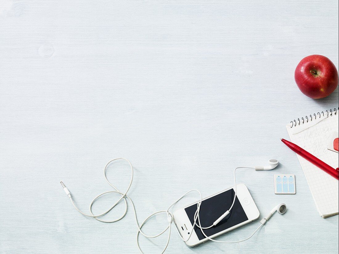 An arrangement featuring an apple, a shopping list and an iPod