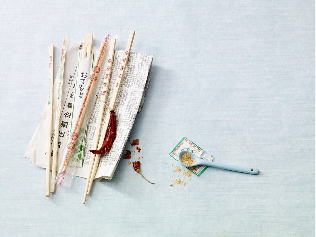 An arrangement of chopsticks on an oriental newspaper
