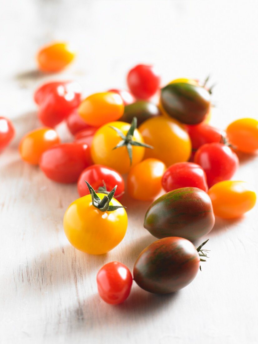 Various tomatoes on a white wooden surface