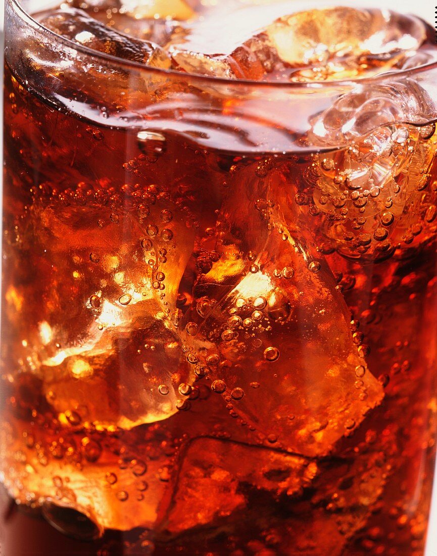 A glass of cola with ice and bubbles (close-up)