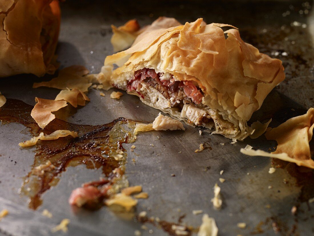Chicken, fig, ham and feta filo pastry parcels on a baking tray