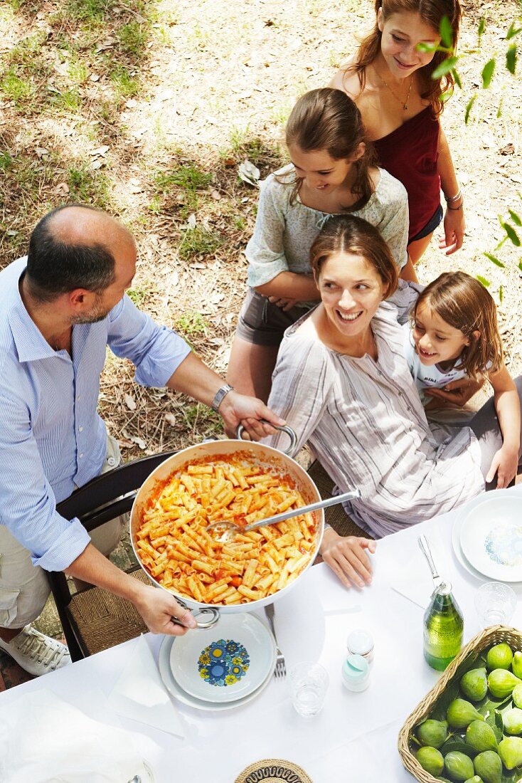 Familie isst zusammen im Garten