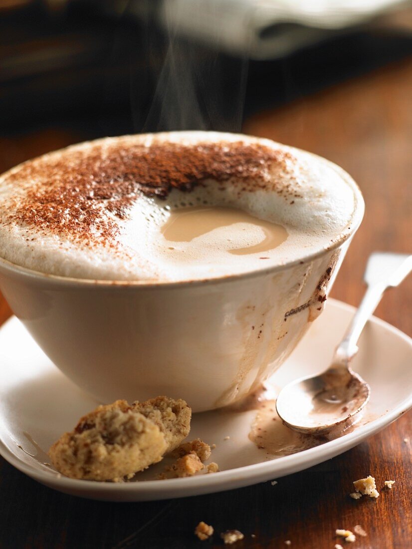 Eine Tasse dampfender Cappuccino mit Milchschaum