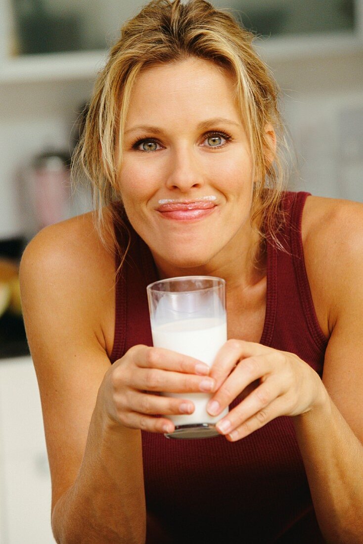 Lächelnde Frau mit Milchbart
