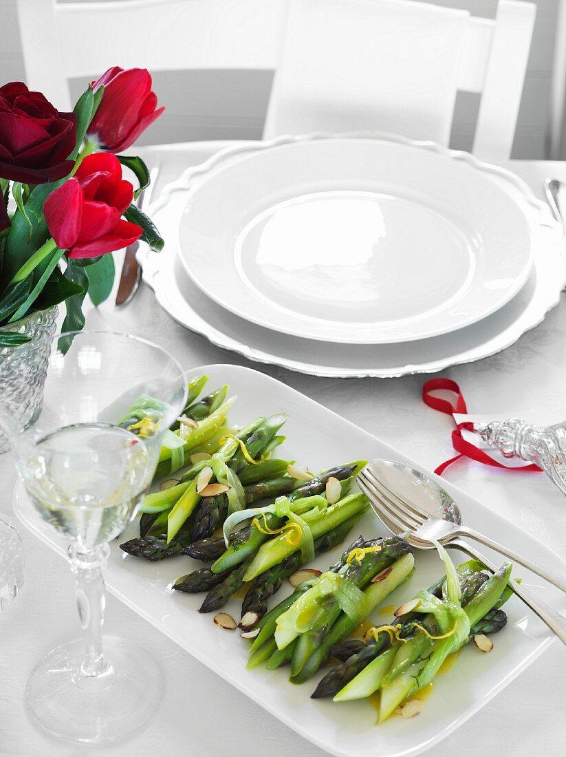 Cooked asparagus with lemon on a table set for Christmas dinner