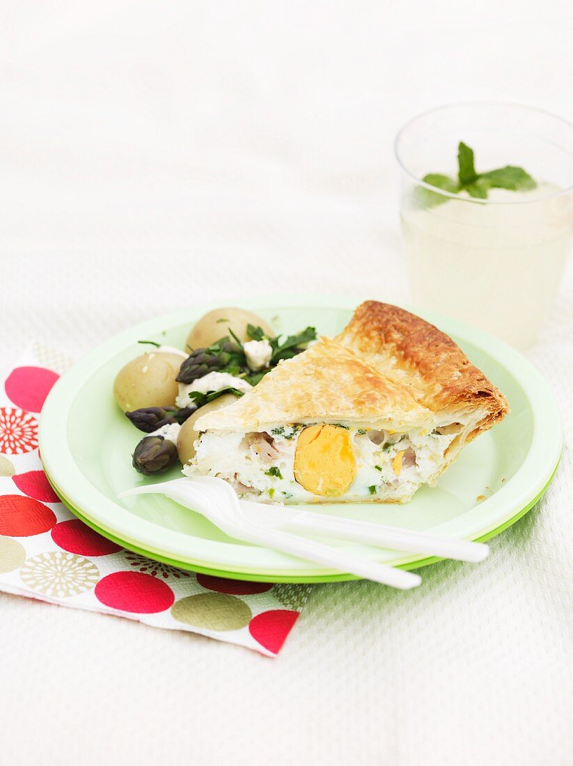 A slice of bacon and egg pie on a picnic plate