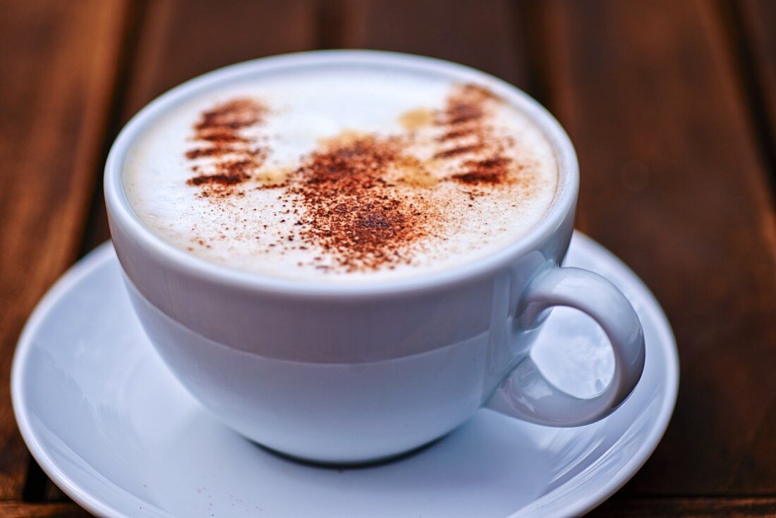 Eine Tasse Cappuccino mit Kakaopulver