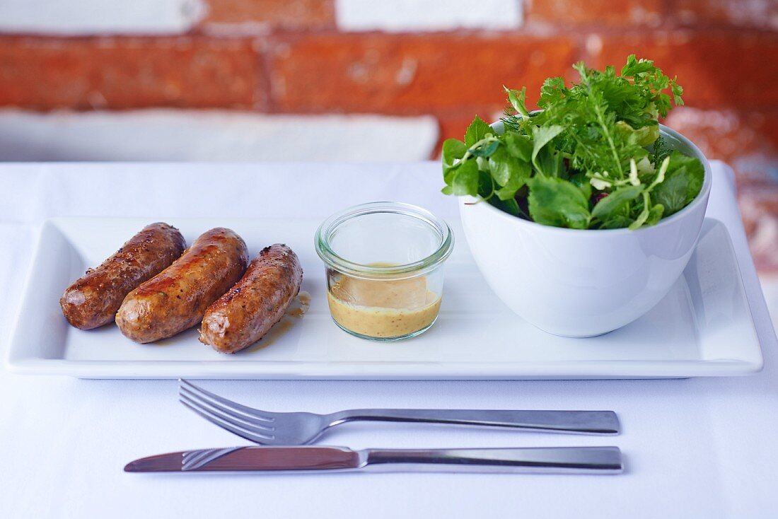 Game sausages with herb salad