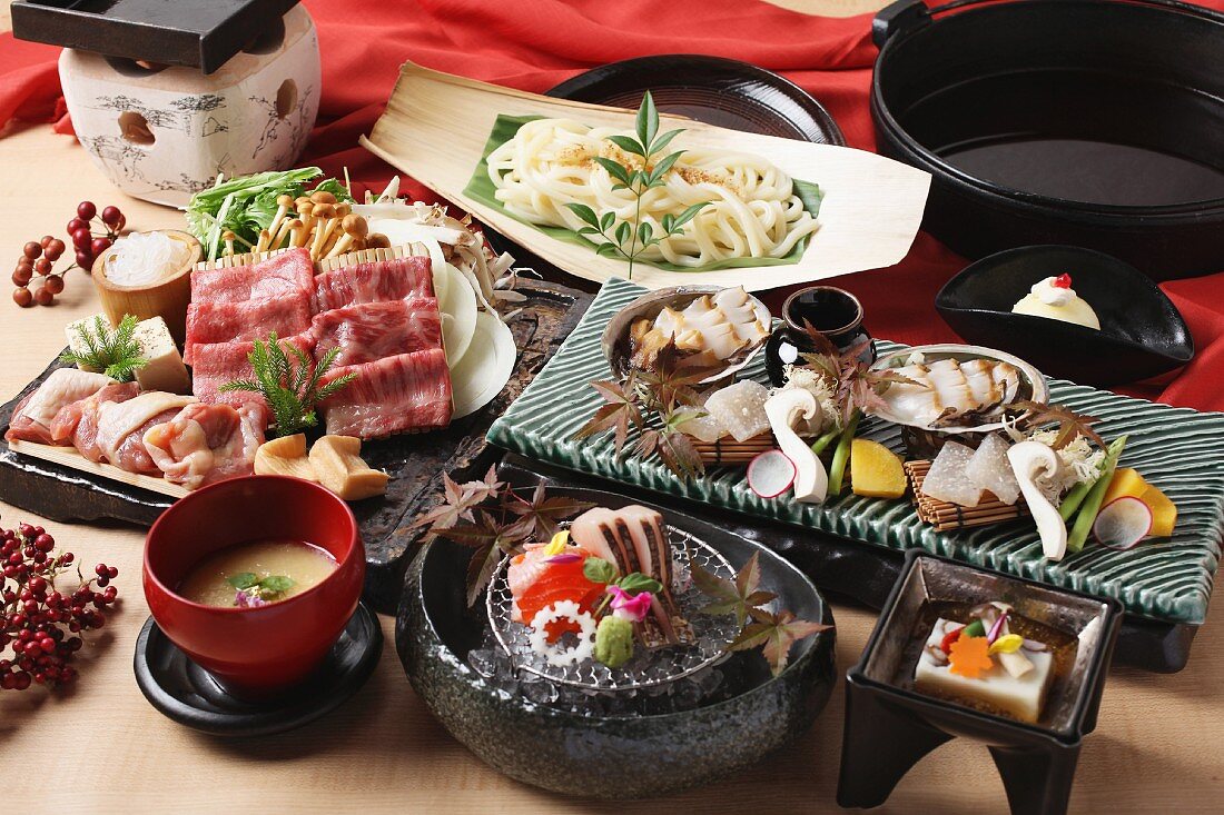 Japanese party dishes with beef, udon noodles and sashimi (Japan)