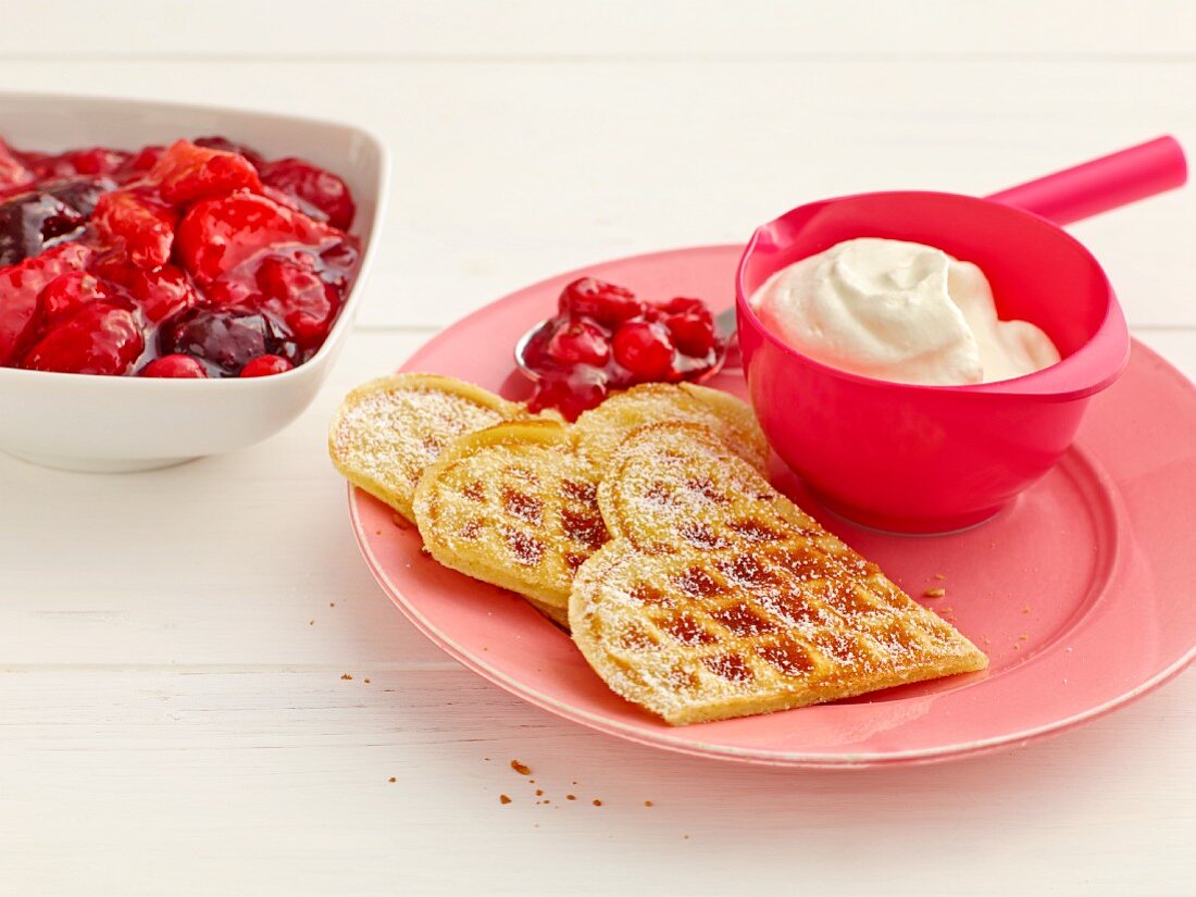 Waffles with red berry jelly and whipped cream